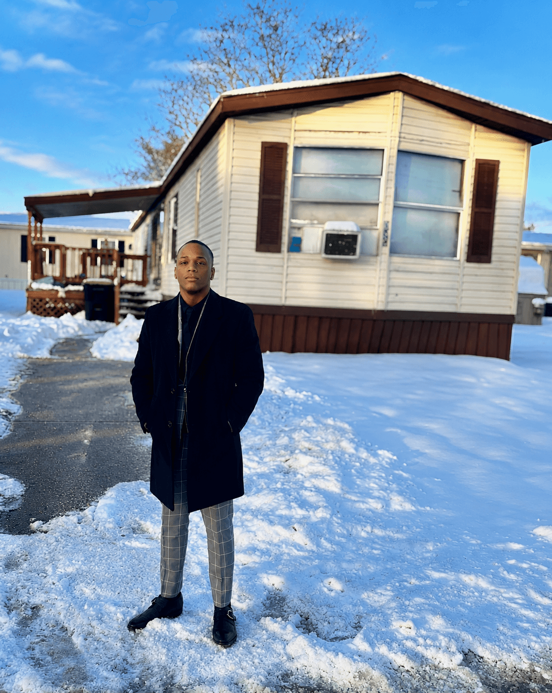 Darius James standing in front of the trailer he grew up near, Ypsilanti, Michigan